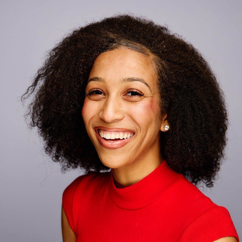 Smiling woman with curly hair wearing red