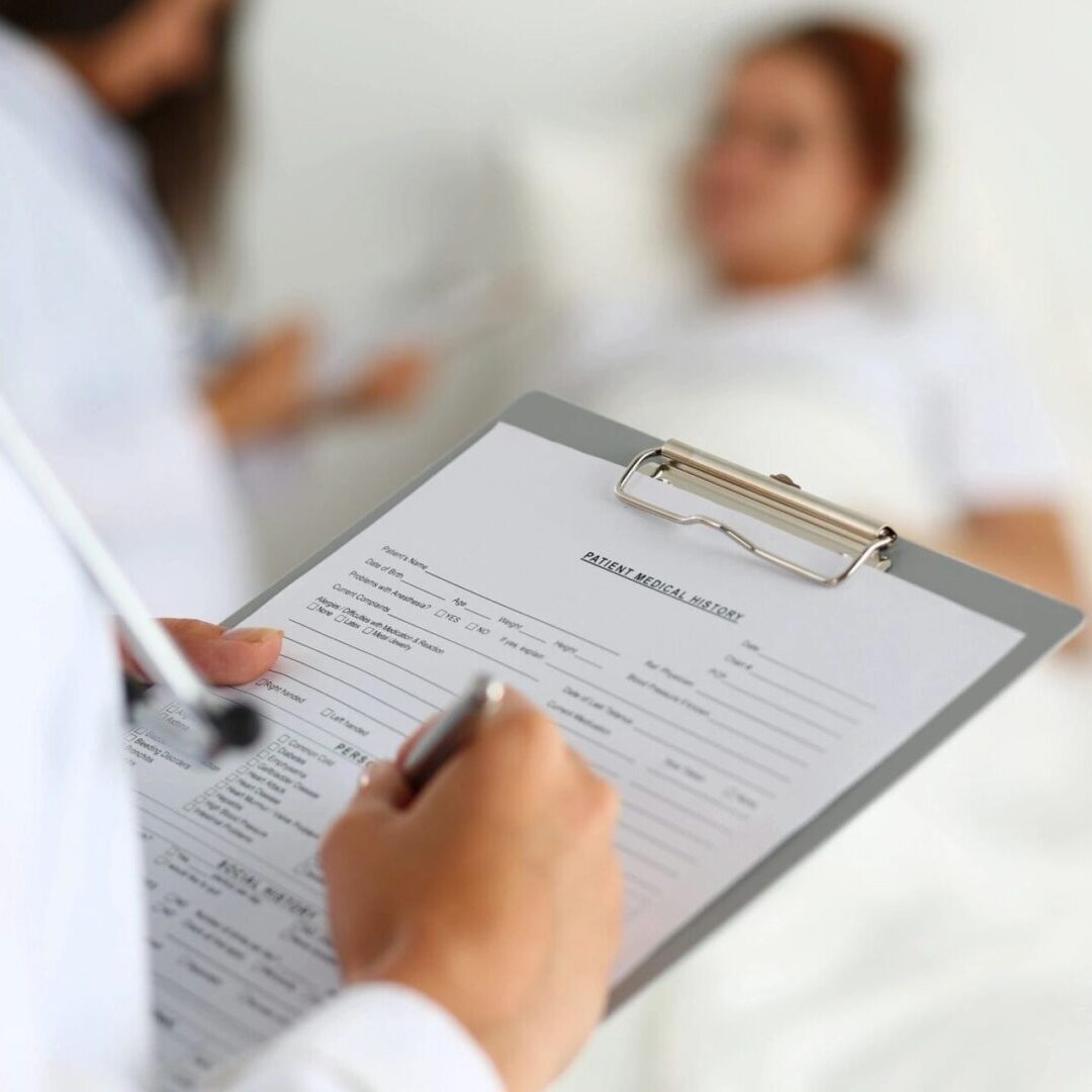 Doctor writing patient medical history on clipboard
